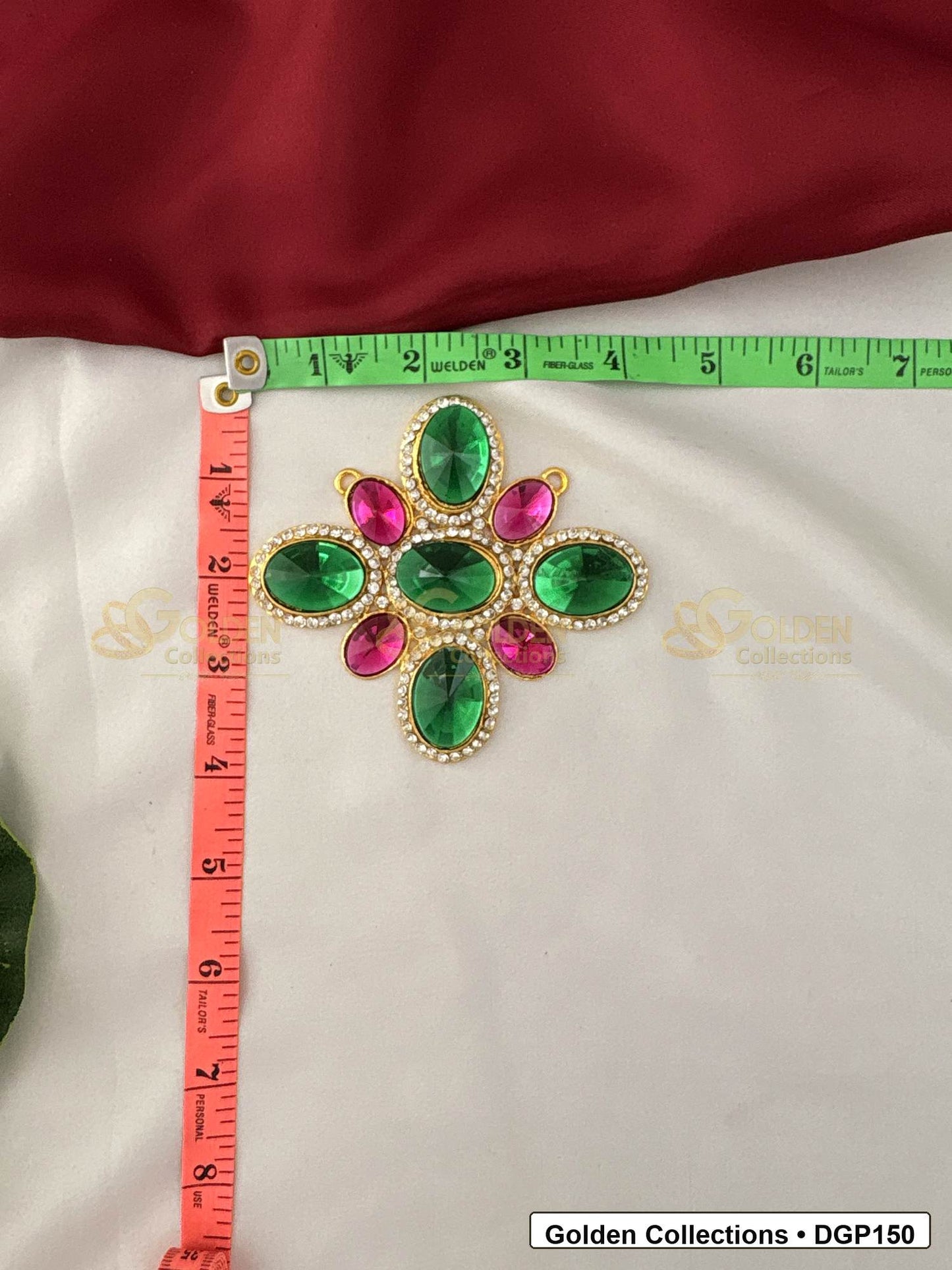 Measurement photo showing 4 x 3.5 Inches floral green and pink stone deity pendant for idol alankaram with ruler for idol alankaram