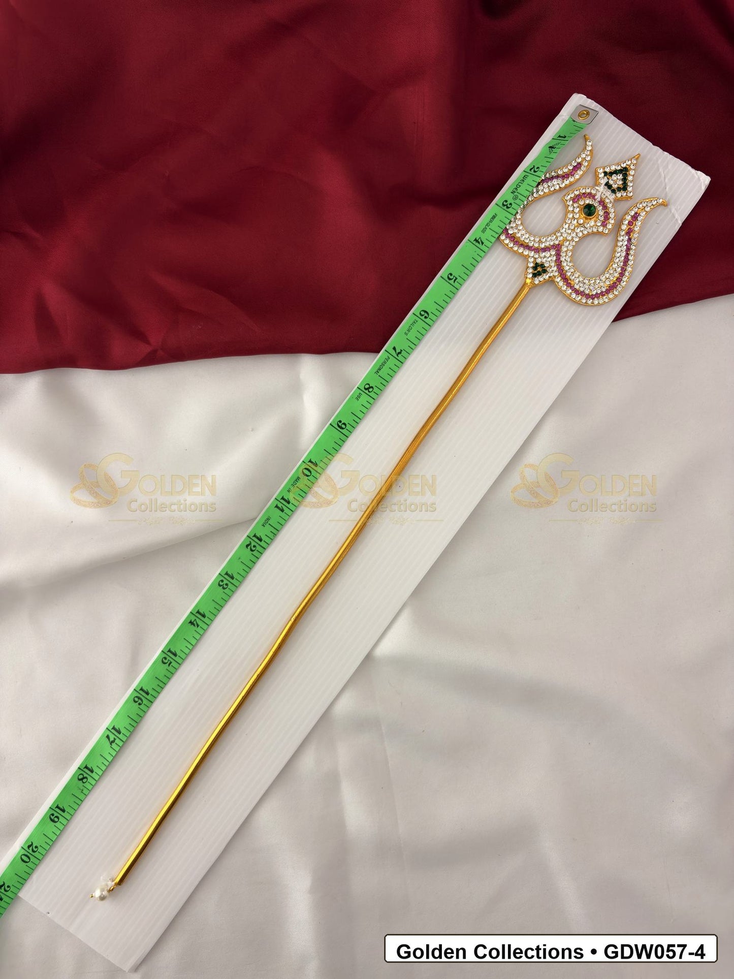 Measurement photo showing 19 Inches gold-tone trishul for idol alankaram with measuring tape for idol alankaram