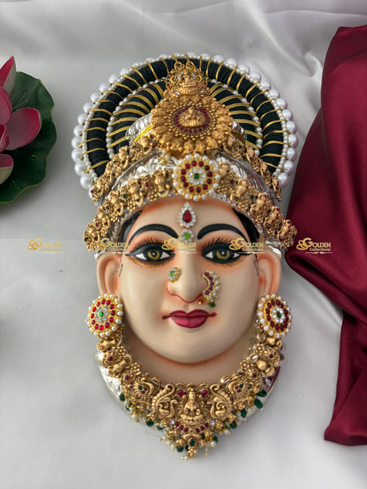 Decorative mask with gold and gemstone jewelry on a white background