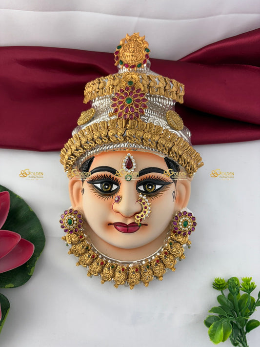 Decorative mask with gold and silver jewelry on a white background