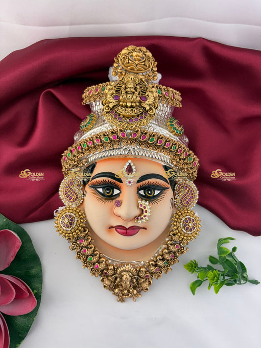 Decorative mask with gold and gemstone details on a red fabric background