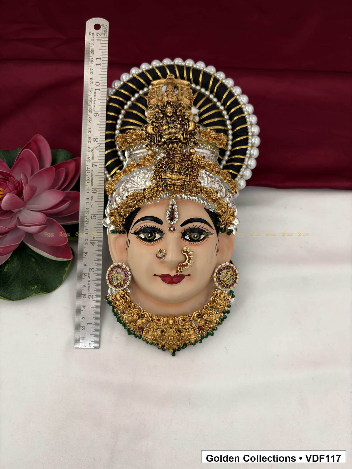 Measurement view of Varalakshmi Tanjore Face with Tall Figure Crown and Green Bead Fringe Necklace with ruler beside the product