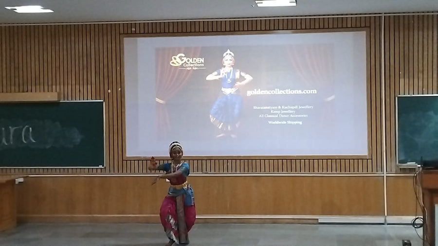 Bharatanatyam dancer performing at Aakara during Pearl 26 with the Golden Collections dance jewellery sponsor screen visible at BITS Pilani Hyderabad Campus.