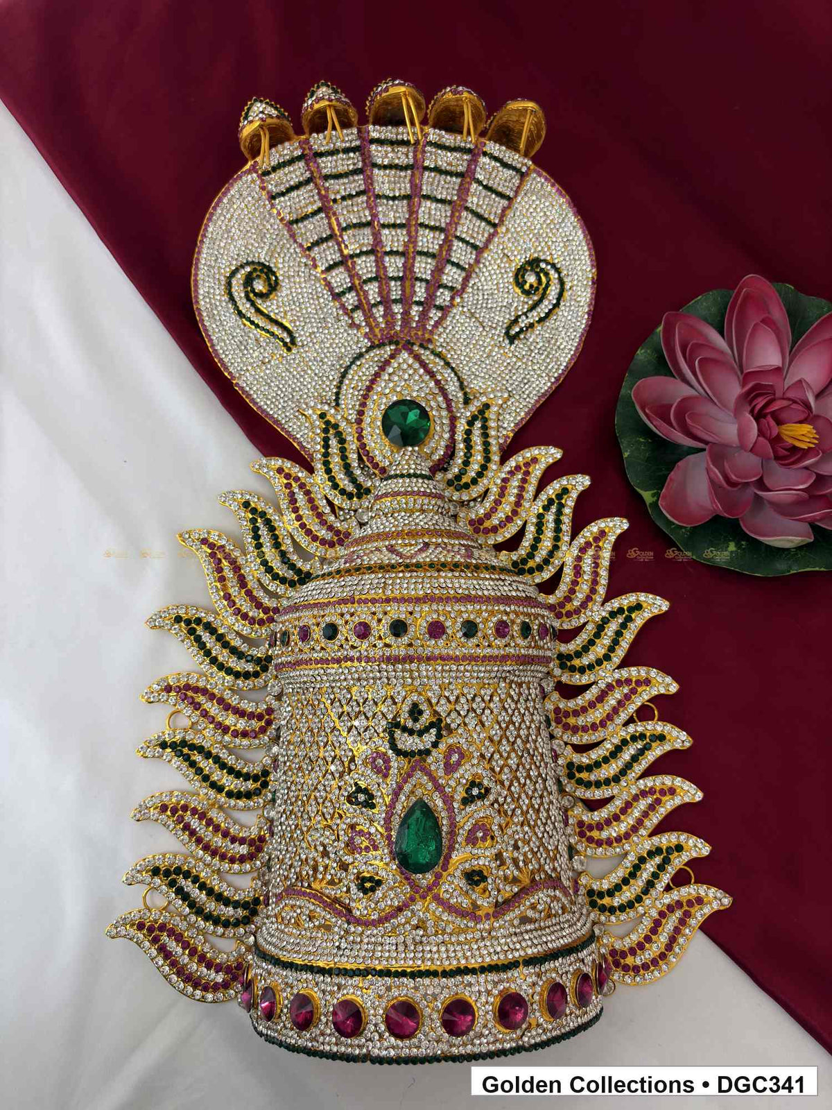 Front view of crown with five hood-like crest tips, paired green scrolls, pink and green accents, and paisley-shaped side projections.