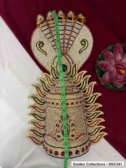 Crown with a vertical measuring tape across its centre, showing five raised crest tips and alternating green and pink paisley-shaped side details.