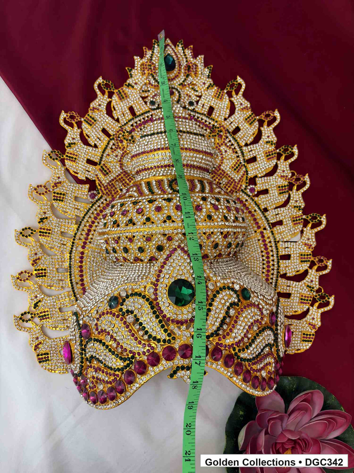 Deity crown with a measuring tape running vertically from the top ornament down across the front.