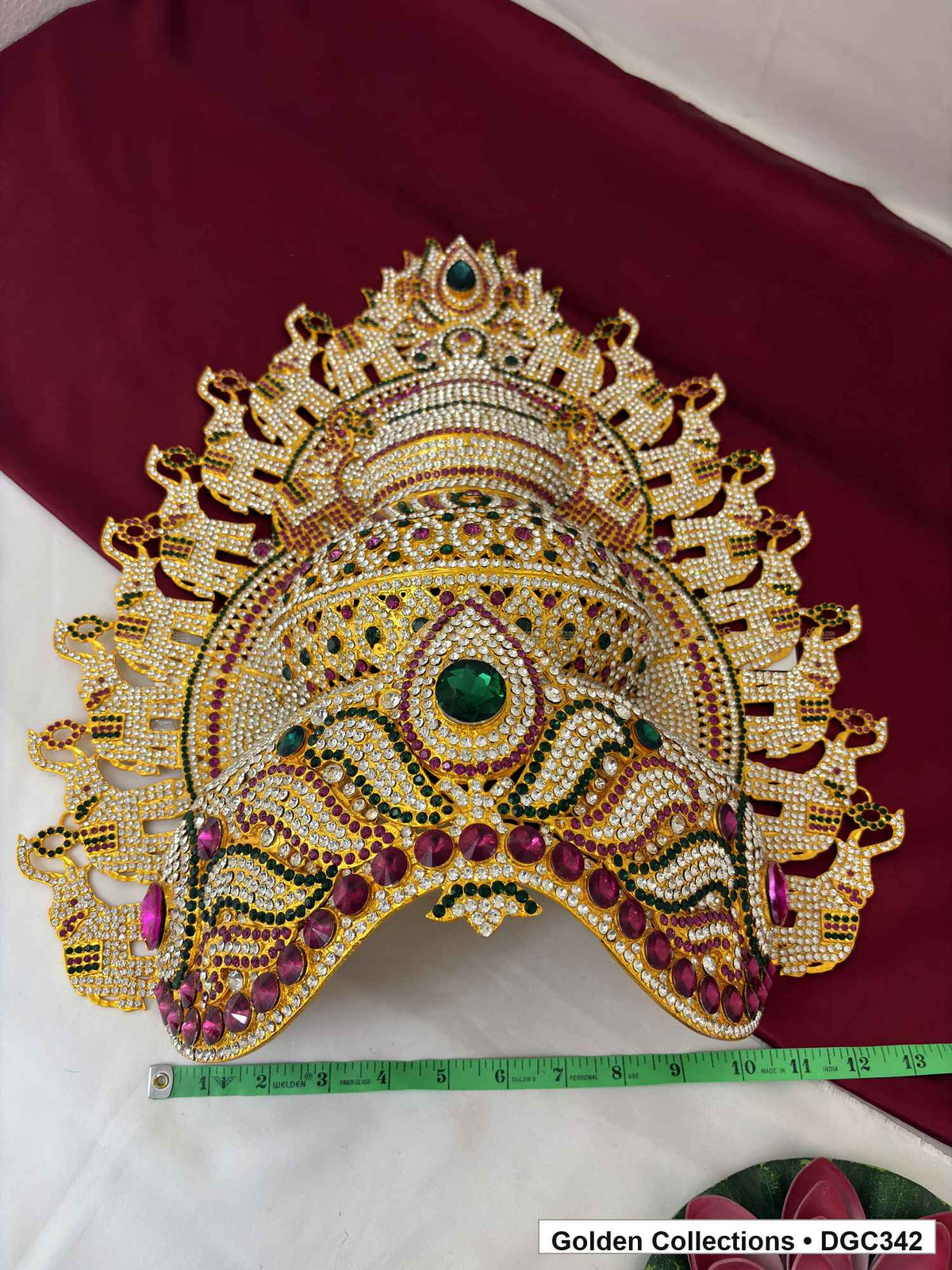 Front view of the elephant-motif deity crown with a measuring tape laid horizontally below its lower edge.