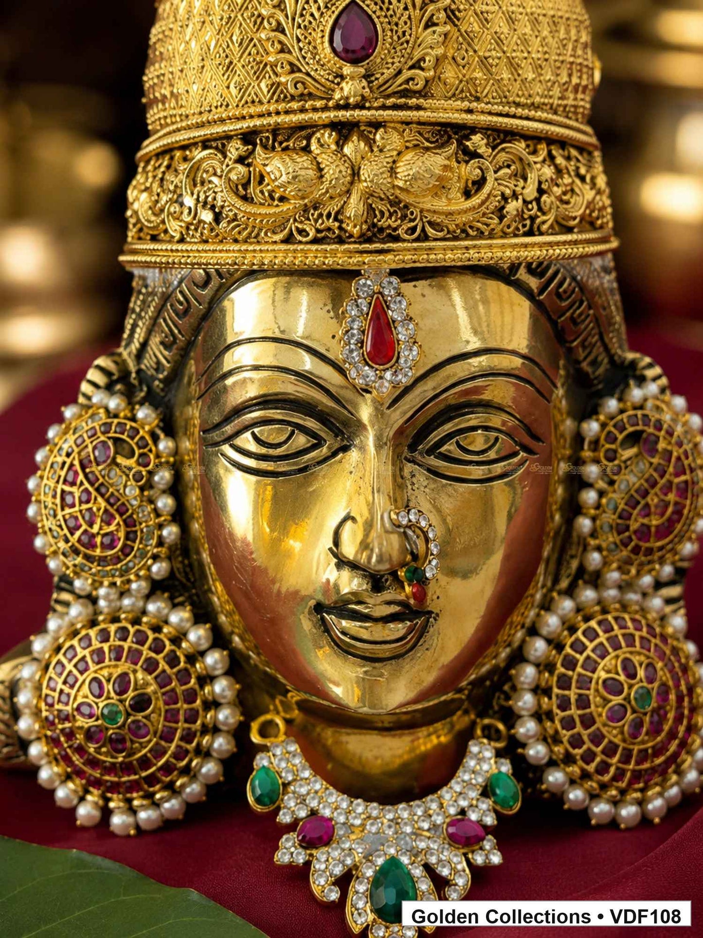 Brass Varalakshmi face with pink-green Jadau earrings and green teardrop AD necklace close-up