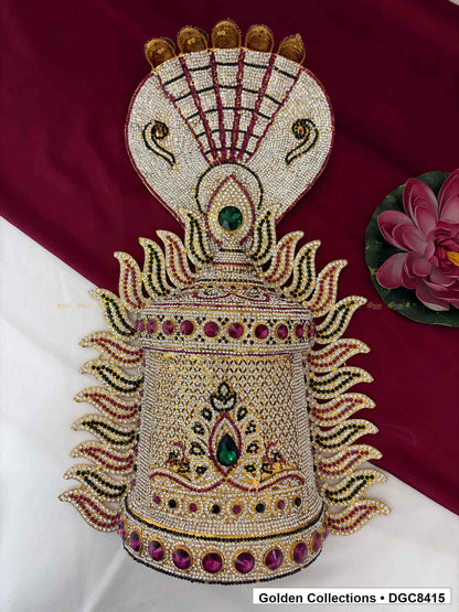 Front view of the half-round deity stone crown with a snake-motif top, white decorative details, and green and magenta accents.