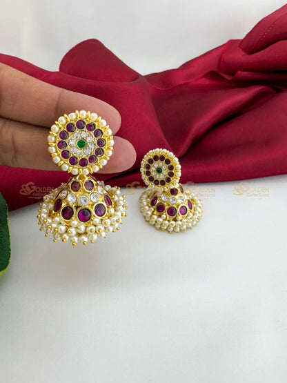 Golden Collections Kemp CZ Pearl Jhumki Earrings - Pair display against a red drape, highlighting the genuine ruby Kemp, CZ, and pearl details.