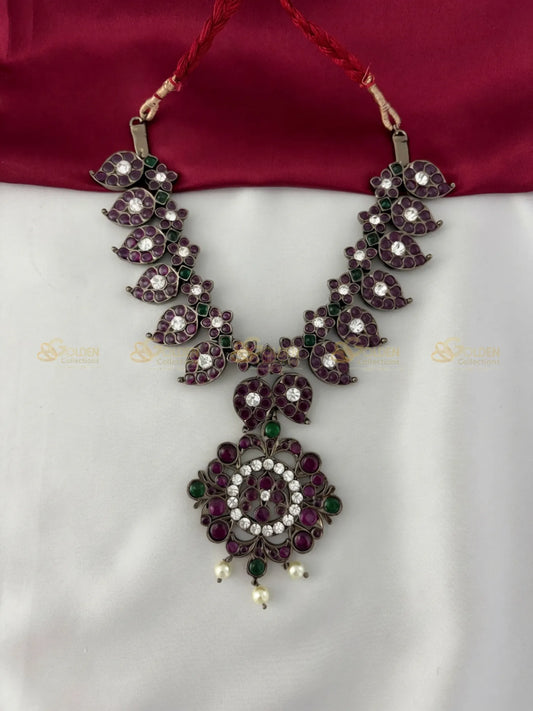 Golden Collections Kemp Petal 'V' Design Short Necklace - Front view showcasing intricate purple and green kemp stones with white accents.