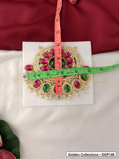 Measurement photo showing 4.25 x 5 Inches oval pink and green stone deity pendant for idol alankaram with ruler for idol alankaram