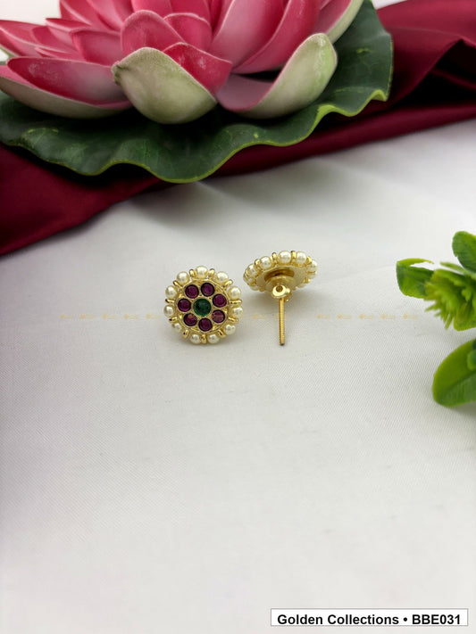 angled product view of Real kemp stud earrings with red and green stones from Golden Collections
