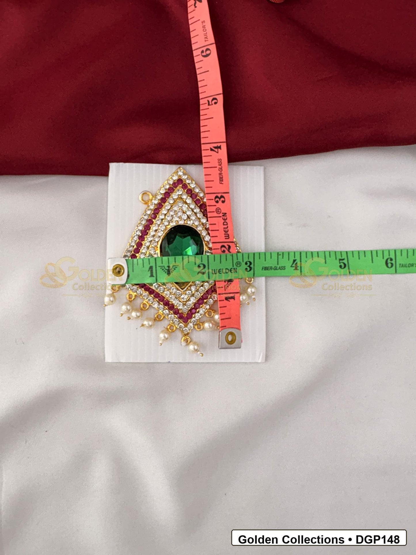 Measurement photo showing 3.5 x 3 Inches teardrop green stone deity pendant for idol alankaram with ruler for idol alankaram