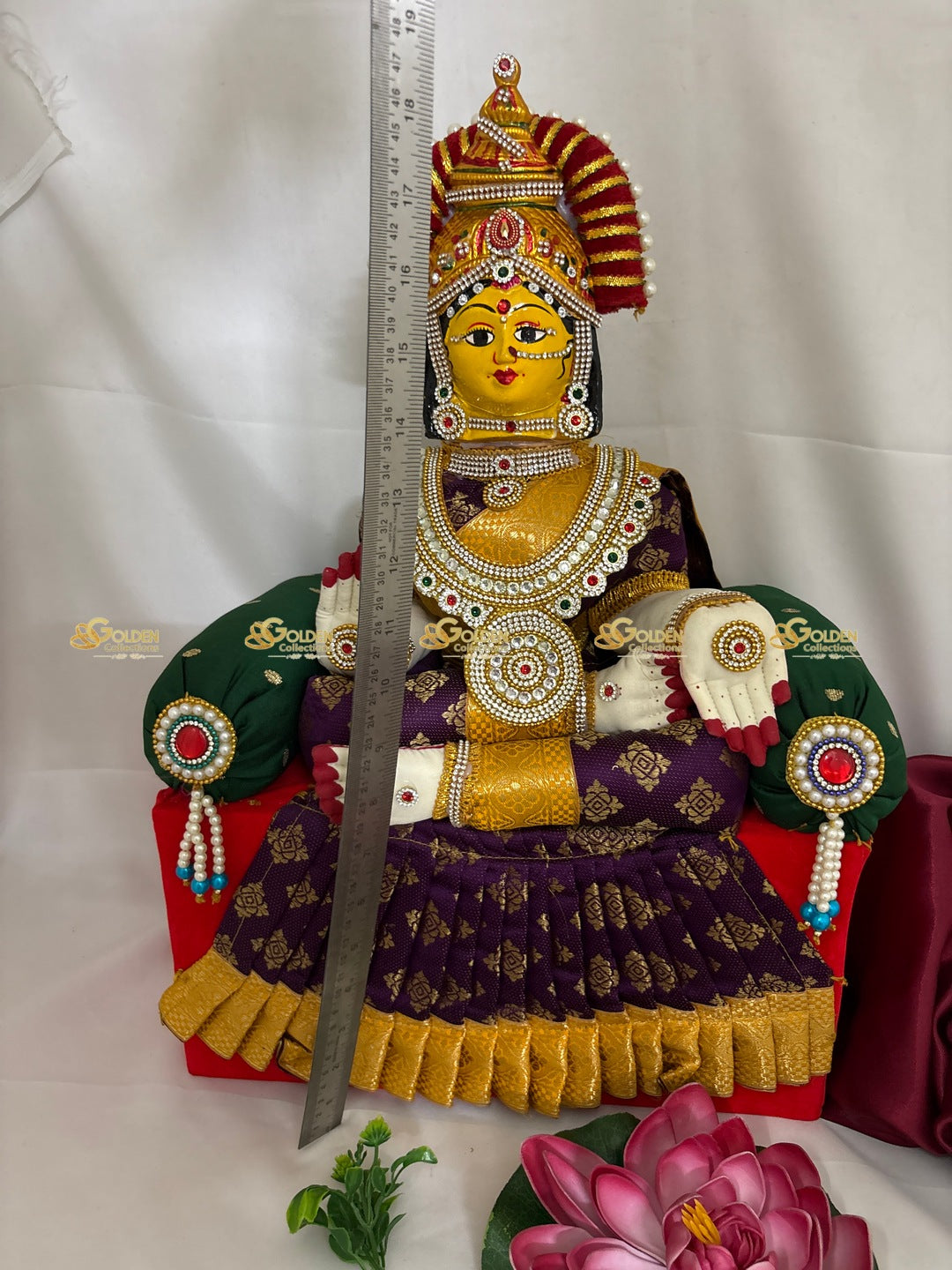 Decorative statue with intricate jewelry and a sword, placed on a white background.