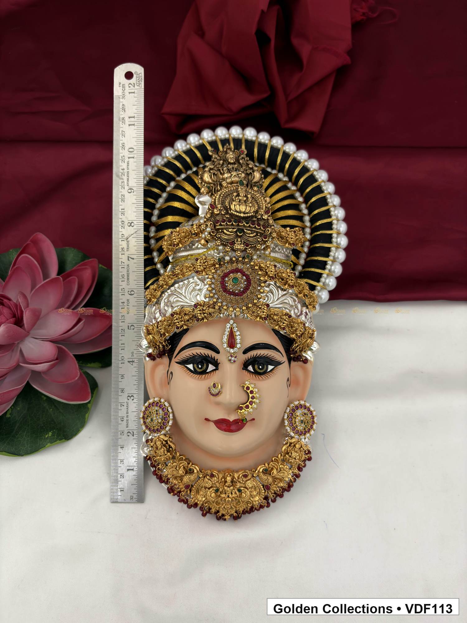 Measurement view of Varalakshmi Tanjore Face with Red-Green Centre Crown and Maroon Fringe Necklace with ruler beside the product