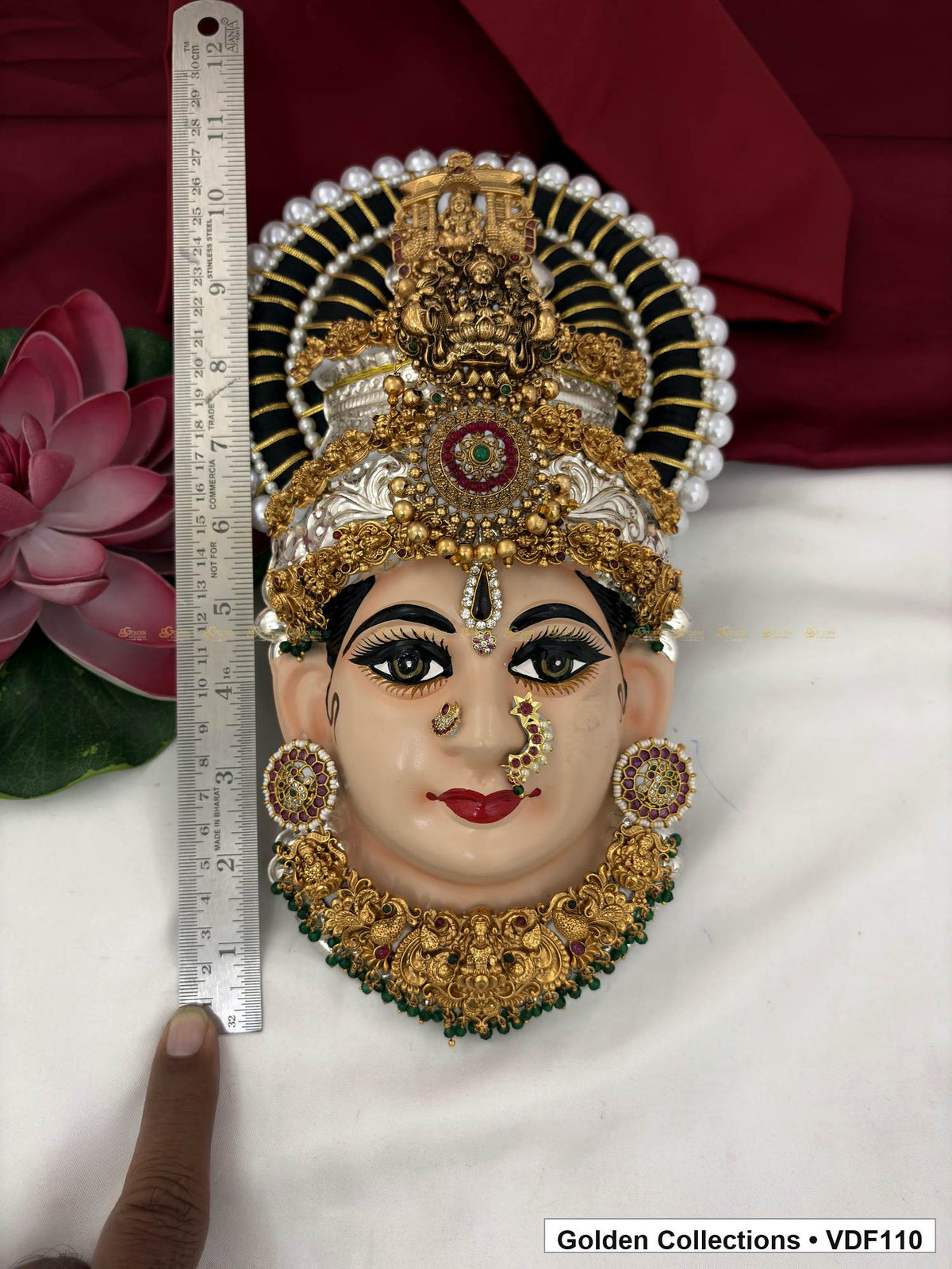 Measurement view of Varalakshmi Tanjore Face with Red-Green Medallion Crown and Green Fringe Necklace with ruler beside the product
