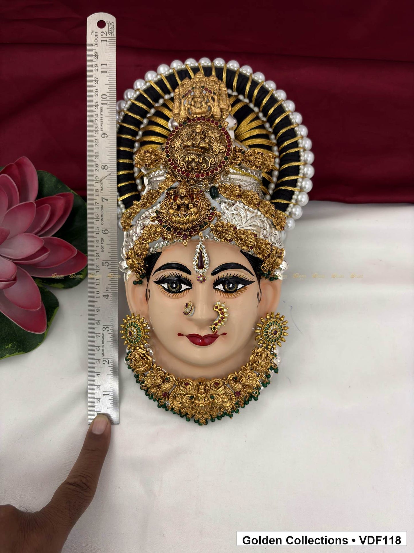 Measurement view of Varalakshmi Tanjore Face with Round Red Medallion Crown and Green Fringe Necklace with ruler beside the product