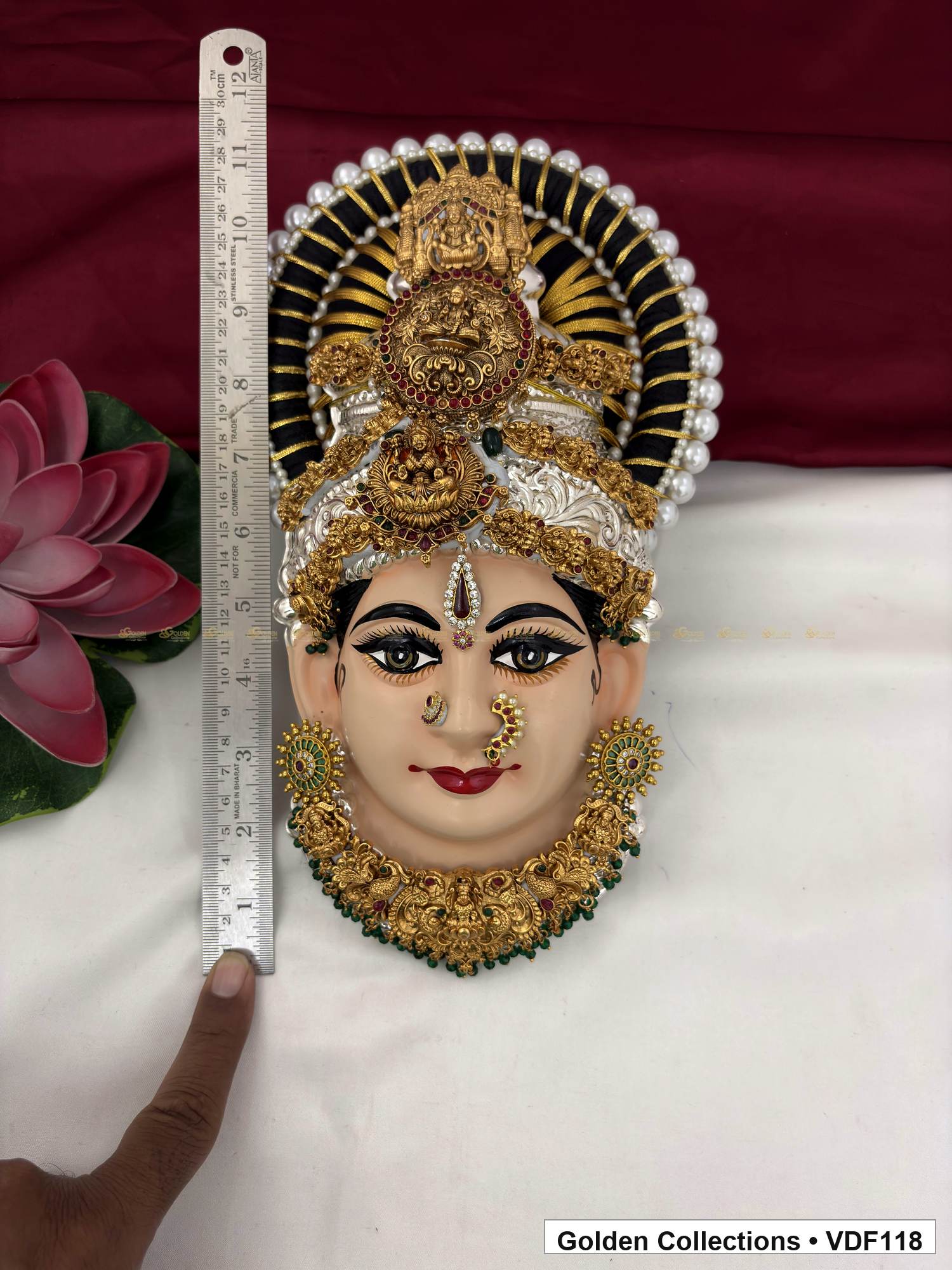 Measurement view of Varalakshmi Tanjore Face with Round Red Medallion Crown and Green Fringe Necklace with ruler beside the product