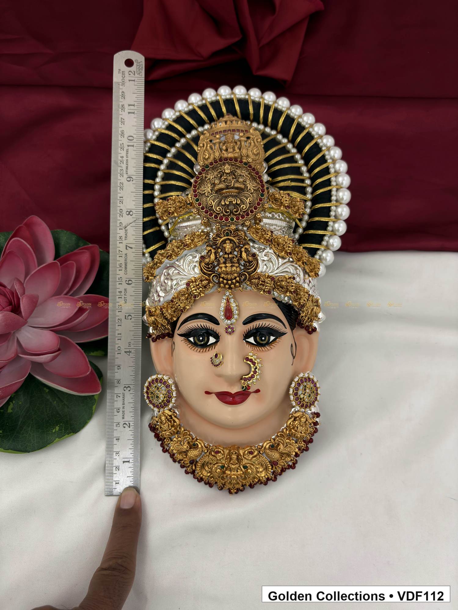 Measurement view of Varalakshmi Tanjore Face with Stacked Medallion Crown and Broad Sculpted Necklace with ruler beside the product